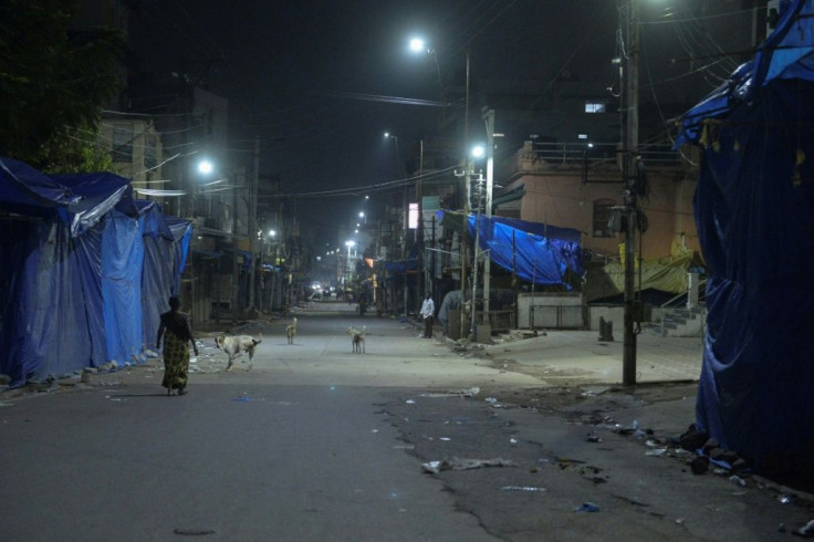 Lockdowns and nightly curfews have returned to several parts of India amid a surge in coronavirus cases -- here, a woman walks on an otherwise deserted street in Hyderabad