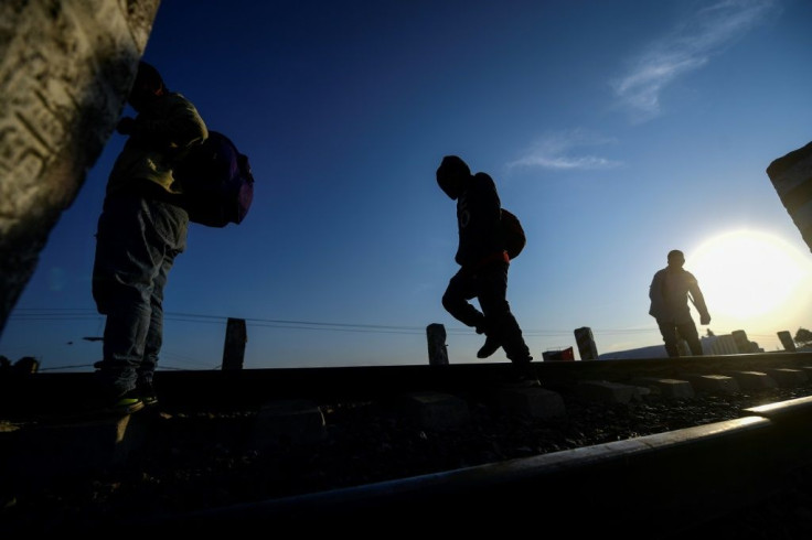 Central American migrants walk on rail tracks in the Mexican state of Tlaxcala on their way to seek safety in the United States in April 2021