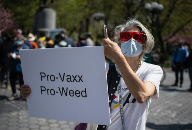 A woman holds up a sign and joints as marijuana activists hand out free joints to vaccinated New Yorkers on April 20, 2021