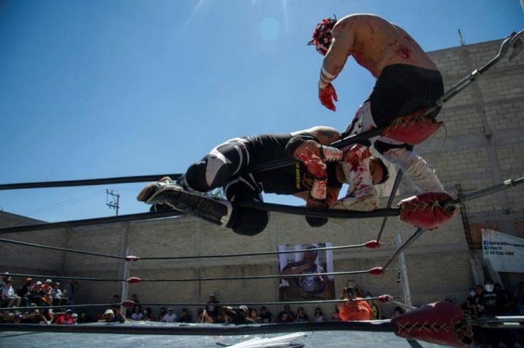 Mexican wrestlers engage in an extreme version of 'lucha libre' in a backyard bout in tribute to wrestler Ovett, who died of Covid-19