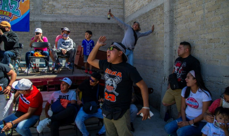 Fans cheer wrestlers taking part in an extreme 'lucha libre' show in a Mexican backyard with little sign of social distancing