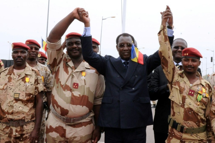 Chad's President Idriss Deby Itno (C) holds hands with Chadian army chiefs and his son Mahamat Idriss Deby (R) in N'Djamena in 2013