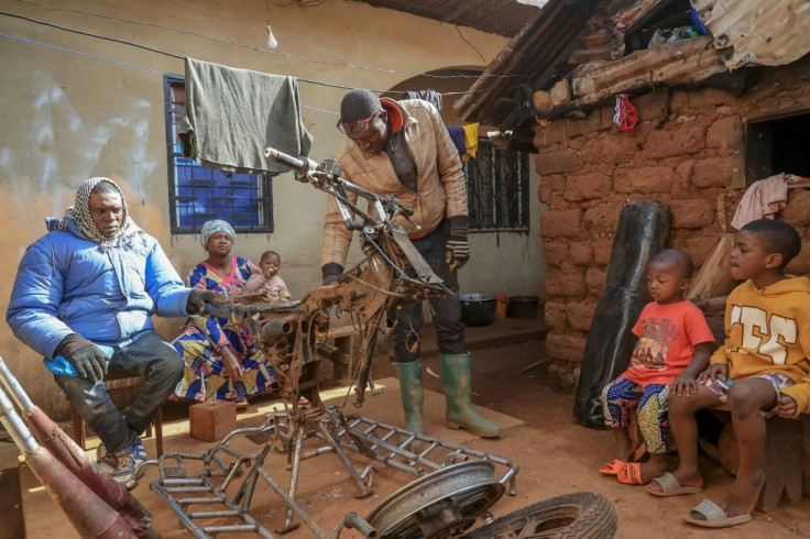Emmanuel Wembe, centre, gets to work customising a motorbike for heavy duty