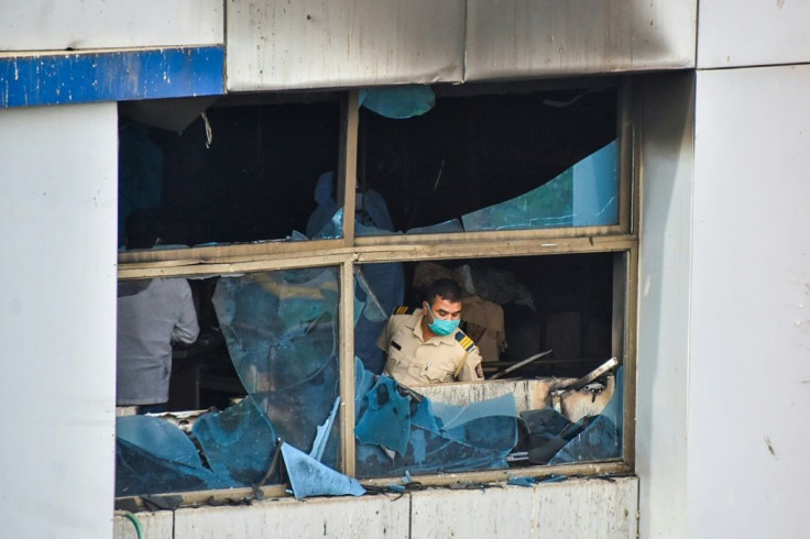 A policeman inspects a burnt out room at Vijay Vallabh Hospital on the outskirts of Mumbai that killed 13 patients