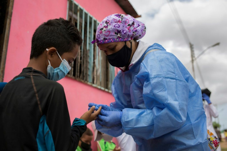 A volunteer with Doctors Without Borders (MSF) takes a blood sample to be tested for malaria in the town of Barcelona, Anzoategui State, Venezuela