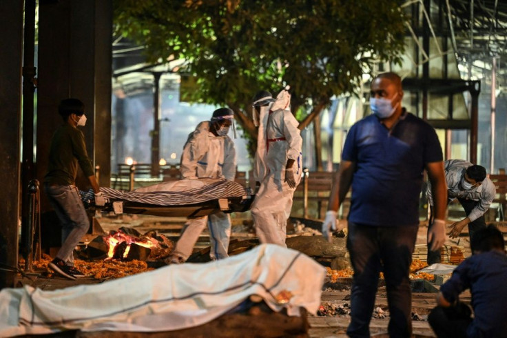 Relatives and staff carry a dead body of a Covid-19 victim at Nigambodh Ghat Crematorium, on the banks of the Yamuna river in New Delhi