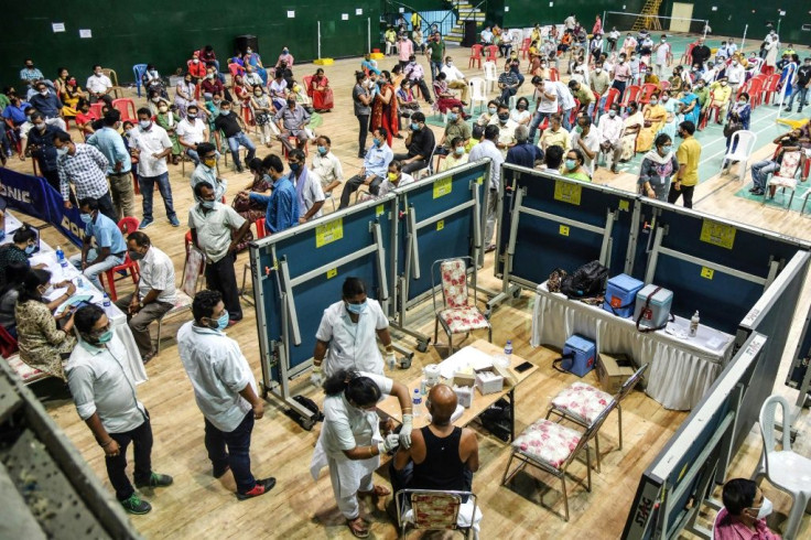 A medical worker inoculates a man with a dose of the Covaxin Covid-19 coronavirus vaccine at an indoor stadium in Guwahati, India