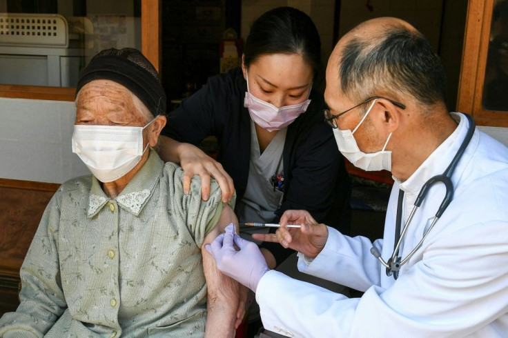 A health worker inoculates an elderly woman with a dose of the Pfizer-BioNTech vaccine in Japan's Nagano prefecture