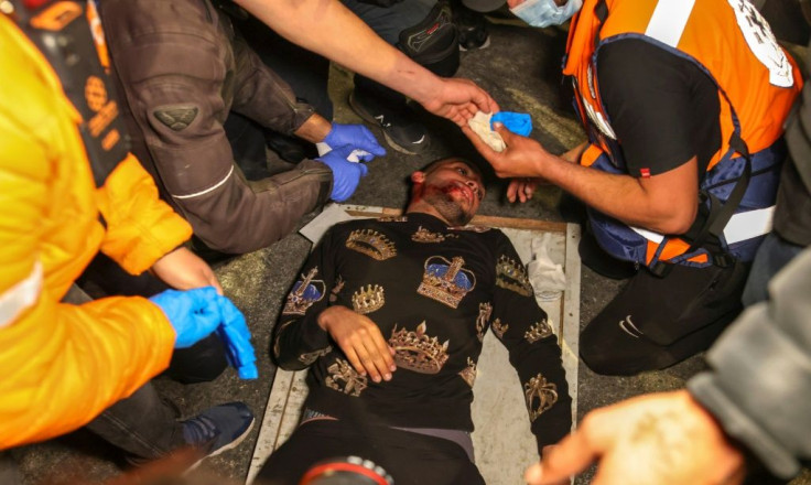 An injured Palestinian protester receives treatment after being hit during clashes outside the Damascus Gate in Jerusalem's Old City on April 22, 2021