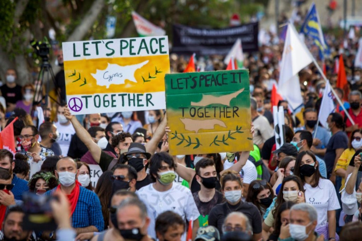 Cypriots rallied Saturday on both sides of the divided capital Nicosia, with these marchers holding placards in the self-declared Turkish Republic of Northern Cyprus