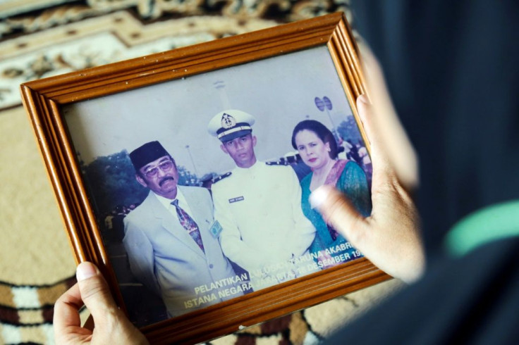 A family member holds a photograph of Marine Colonel Harry Setiawan, commander of the Indonesian navy's KRI Nanggala submarine
