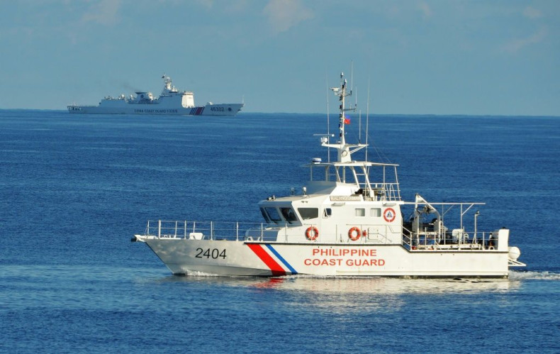 A Philippine coast guard ship sails past a Chinese coast guard ship near Scarborough shoal in the South China Sea in May 2019