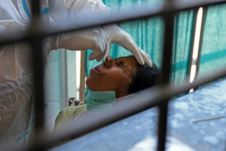 A health worker collects a nasal swab sample from a woman to test for the Covid-19 coronavirus in Amritsar, India on April 18, 2021