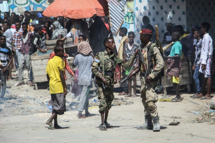 Members of the military force supporting opposition leaders watch over a street in Mogadishu