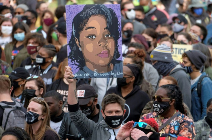 A protestor displays a portrait of Breonna Taylor during a rally in remembrance on the one year anniversary of her death in Louisville, Kentucky, on March 13, 2021