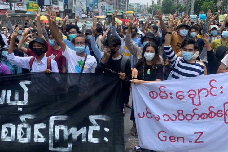 Protesters hold up the three-finger salute in an anti-junta demonstration in Yangon