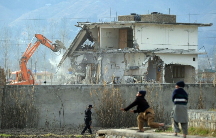 Pakistani children play near demolition works in 2012 on the compound where Al-Qaeda chief Osama bin Laden was slain the year before