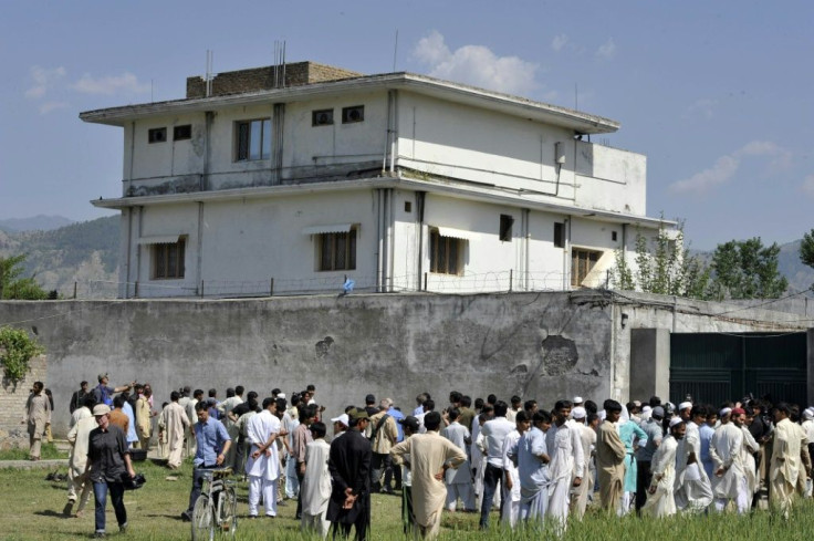 Journalists and local residents gather outside bin Laden's hideout after his death