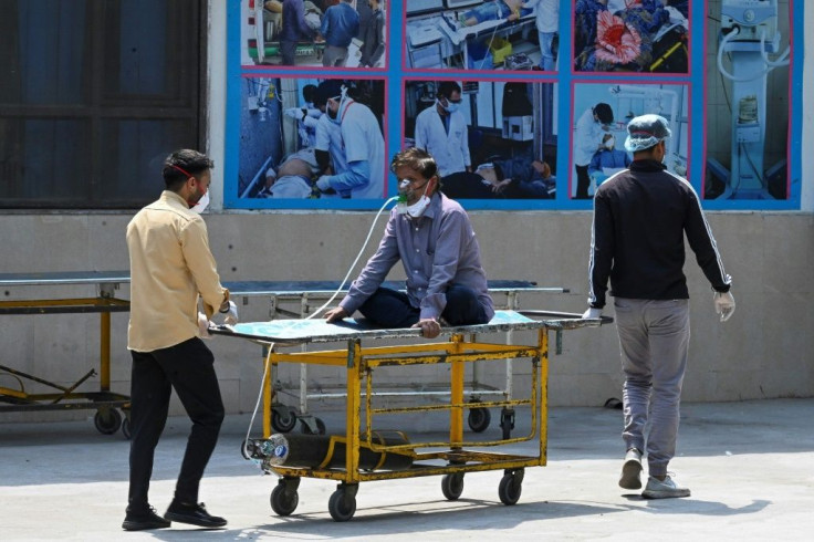A Covid-19 cornavirus patient is shifted to a ward after being admitted at the GTB hospital in New Delhi