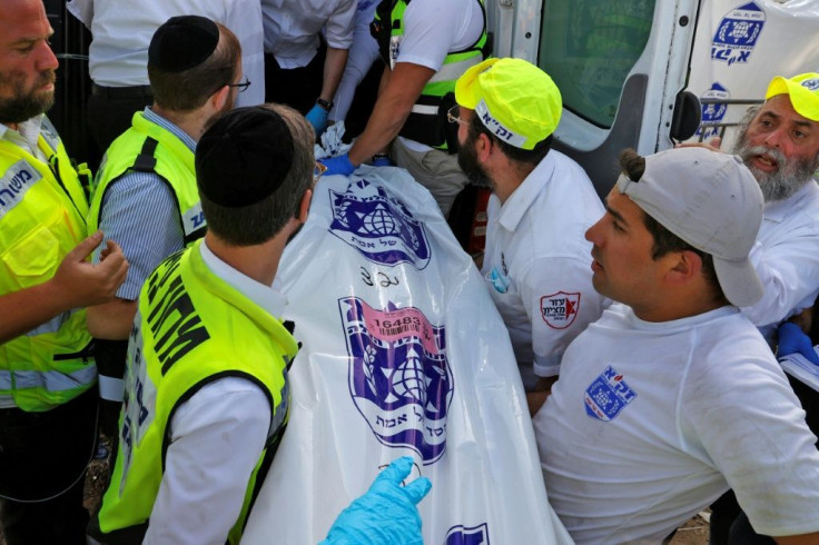 Israeli rescue teams carry a body bag into an ambulance