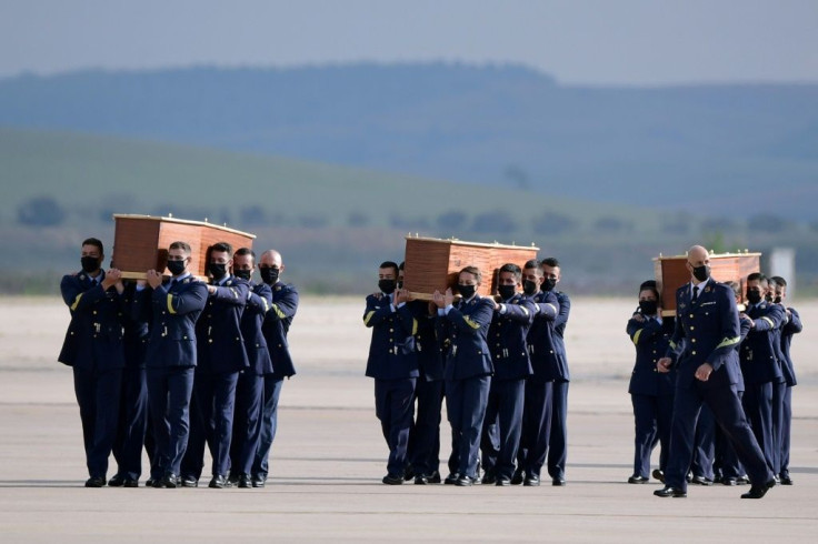 Spanish air force officers carried the coffins containing the bodies of the three Europeans killed