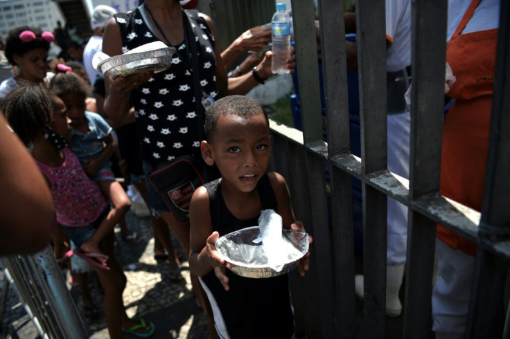 A boy receives a meal in a queue at a food distribution centre in Rio de Janeiro, Brazil, on March 24, 2021: unemployment figures in Brazil are hitting record levels