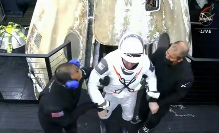 A screen grab from NASA's live feed shows Michael Hopkins from SpaceX's Crew Dragon spacecraft exiting the capsule after its return to Earth