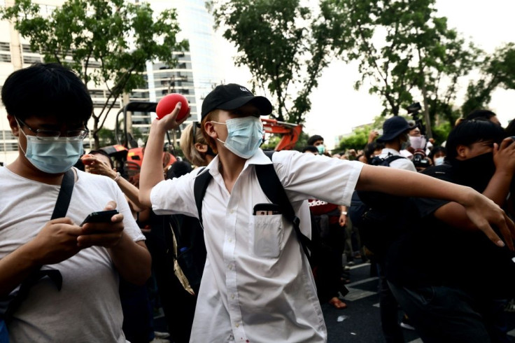 A pro-democracy protester prepares to throw a water balloon at the court