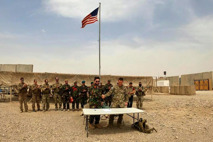 A US and Afghan soldier shake hands during the handover ceremony at Camp Antonik in Helmand province