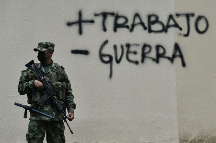 A soldier guards a street in Colombia after a protest against a tax reform bill
