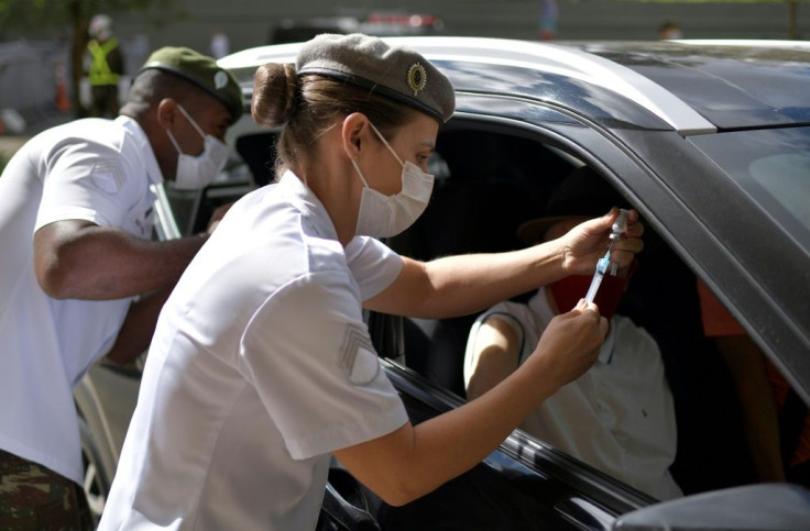 Military personnel vaccinate the elderly at a drive-through vaccination centre in Brazil