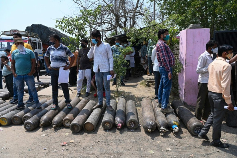 People wait outside to refill their cylinders with oxygen for Covid-19 patients, at a refilling centre in Moradabad