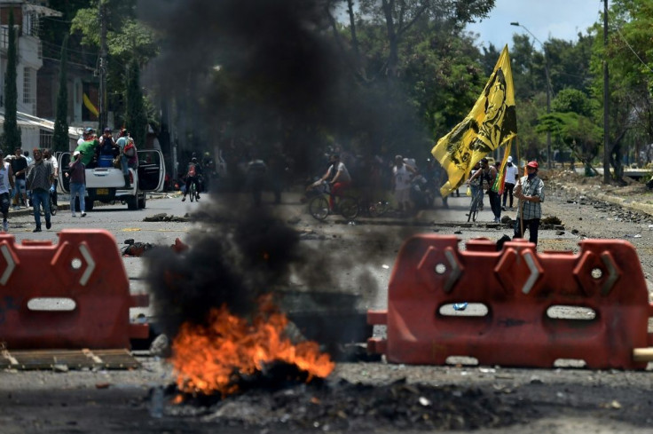 Demostrators block a street with a barricade in Cali on May 5, 2021