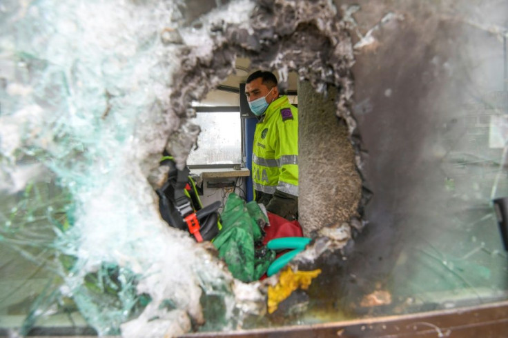 Officers inspect damage caused by demonstrators at a police station in Bogota on May 5, 2021