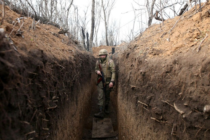 A Ukrainian serviceman walks in a trench on the frontline with Russia-backed separatists near the town of Krasnogorivka in the Donetsk region on April 23, 2021