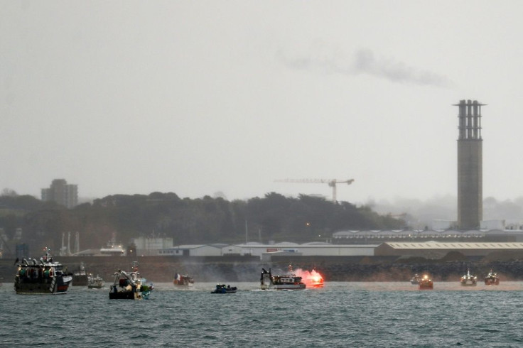 A flare is lit as French fishing boats protest in front of the Jersey port of Saint Helier on Thursday