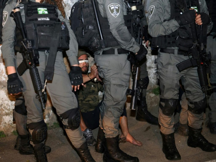 A Palestinian demonstrator is blindfolded and surrounded by Israeli security forces. Police say they made a total of 11 arrests.