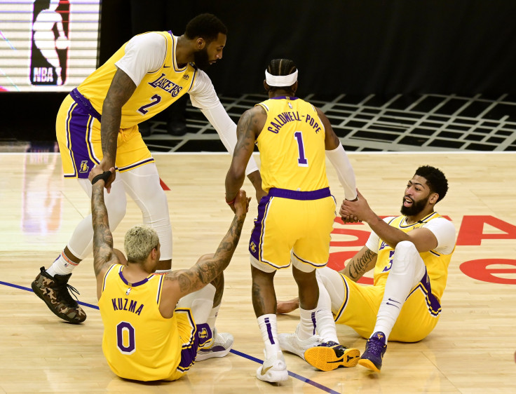 Anthony Davis #3 and Kyle Kuzma #0 of the Los Angeles Lakers reacts as they are helped up off the floor by Kentavious Caldwell-Pope #1 and Andre Drummond #2, after their collision, during the first quarter against the LA Clippers at Staples Center