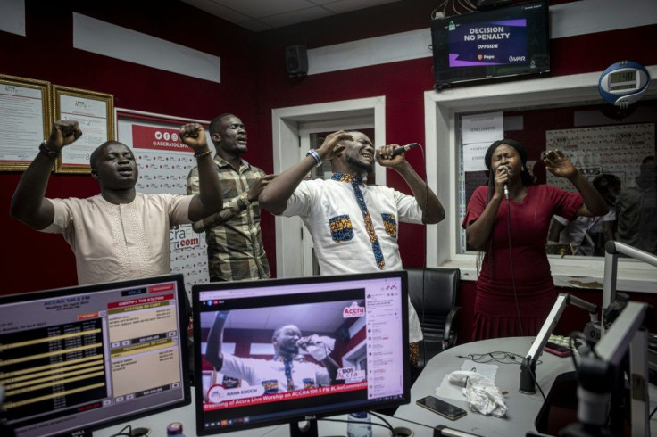 People pray and sing during a worship radio show at Accra FM station in Accra