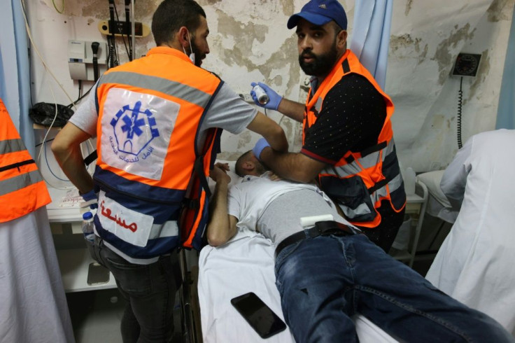 Palestinian medics treat a protester who was injured during clashes with Israeli police at the al-Aqsa mosque compound in Jerusalem