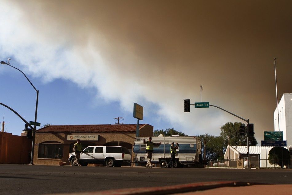 Police officers direct traffic as local residents evacuate from the Wallow Wildfire in Springerville, Arizona
