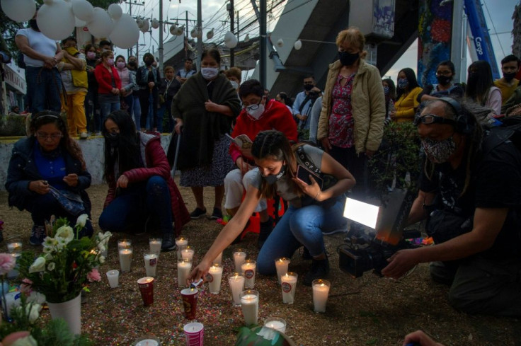 People light candles and place flowers at the site of a Mexico City metro rail accident that left 25 dead and sparked calls for justice