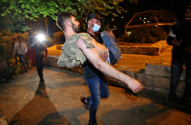 An injured Palestinian protestor is helped during clashes with Israeli police in Sheikh Jarrah in east Jerusalem