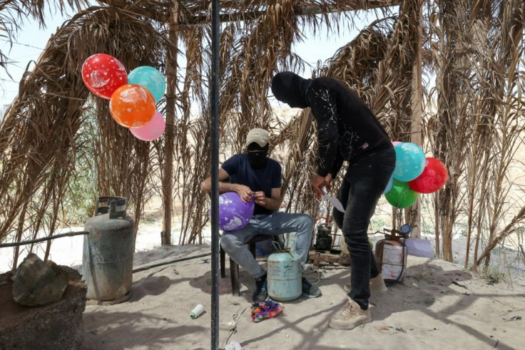 Masked Palestinian supporters of Islamic Jihad prepare incendiary balloons near Beit Lahia in Gaza City, to launch across the border fence towards Israel