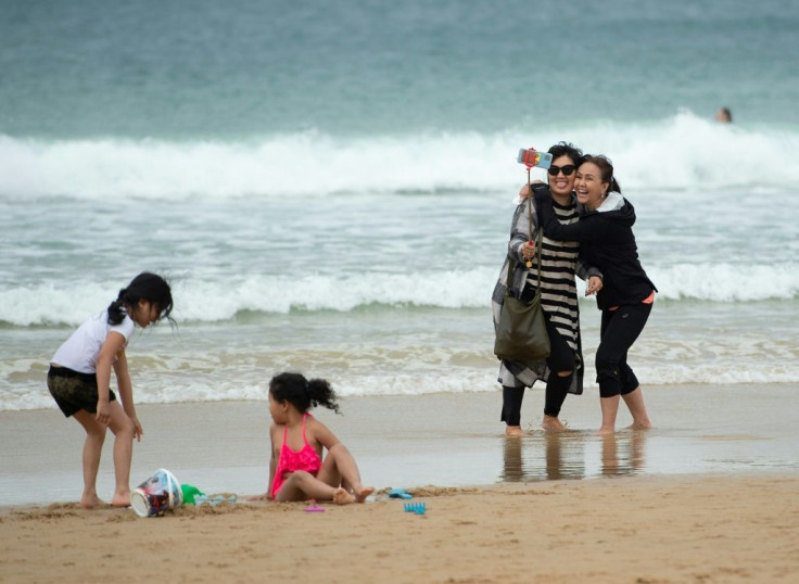 Two women smile as they take a selfie photo on La Concha beach in the Basque resort of San Sebastian after the state of emergency was lifted