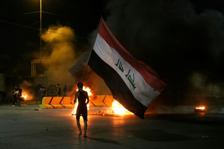 Iraqi protesters burn tyres in front of the Karbala governorate headquarters in the central  city of Karbala on May 9, 2021 following the reported killing of prominent anti-government activist