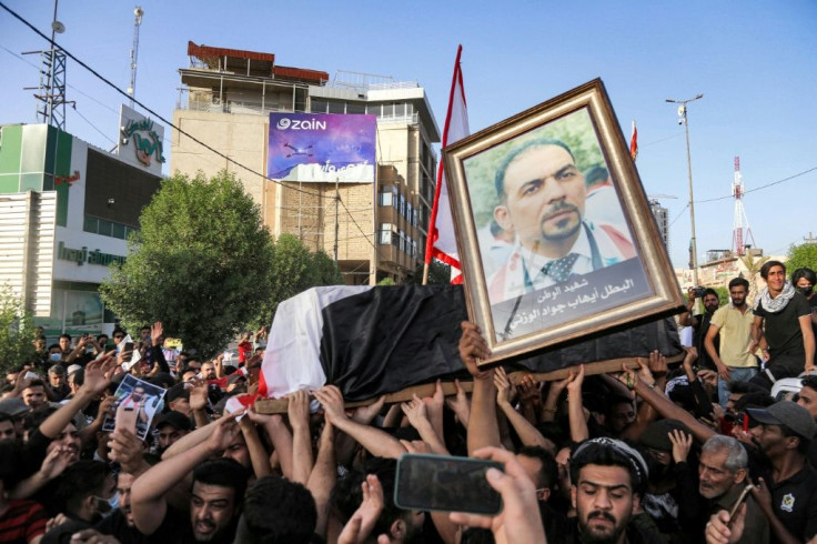 People chant slogans as they march with the body of renowned Iraqi anti-government activist Ihab al-Wazni (Ehab al-Ouazni) during a funeral procession in the central holy shrine city of Karbala