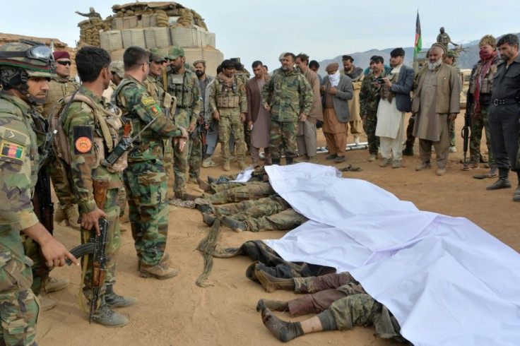 Afghan security forces gather around the bodies of Taliban militants in Nangarhar province in February 2021 -- the Taliban have declared a three-day Eid ceasefire