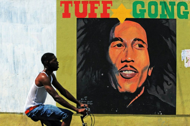 A man pedals past a mural of late reggae legend Bob Marley in Kingston, Jamaica
