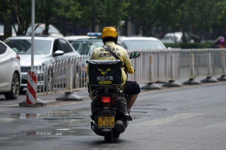 A Meituan food delivery man rides his scooter in Beijing